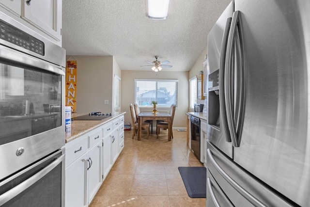 kitchen with white cabinets, black appliances, ceiling fan, and light tile patterned floors