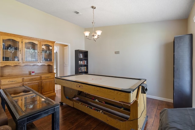 playroom with an inviting chandelier, a textured ceiling, and dark hardwood / wood-style floors