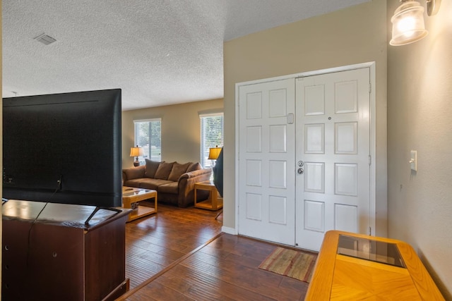 foyer entrance featuring a textured ceiling and dark hardwood / wood-style flooring