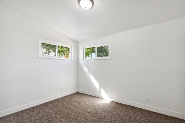 empty room featuring carpet floors and lofted ceiling