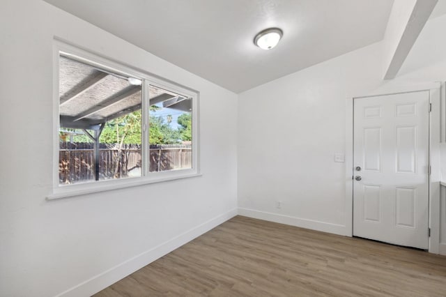 unfurnished room with wood-type flooring and vaulted ceiling