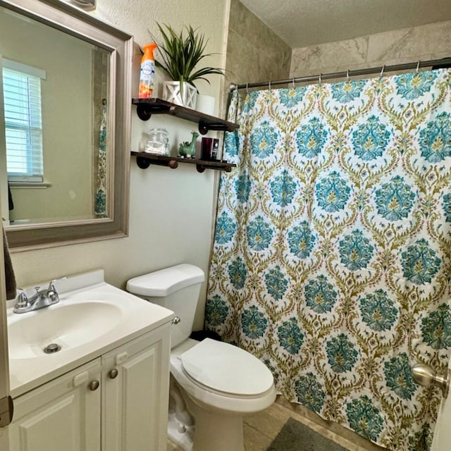 bathroom with toilet, curtained shower, a textured ceiling, and vanity