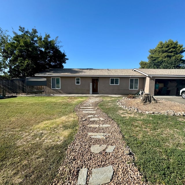 back of property featuring concrete driveway, a lawn, an attached garage, and stucco siding