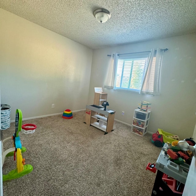 recreation room featuring carpet flooring, a textured ceiling, and baseboards