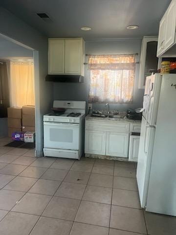 kitchen with white cabinets, white appliances, light tile patterned flooring, and sink