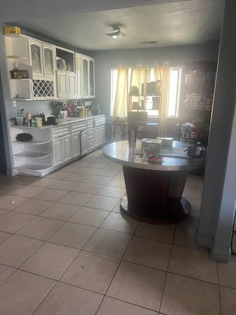 kitchen featuring light tile patterned flooring and white cabinetry