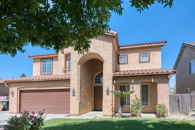 mediterranean / spanish home with a garage and a front lawn