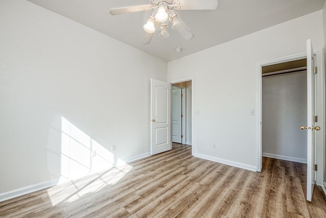 unfurnished bedroom with a closet, light wood-type flooring, and ceiling fan