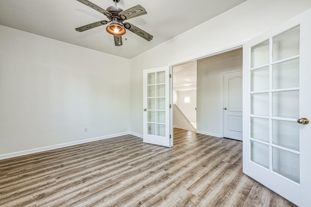 empty room featuring lofted ceiling, french doors, light wood-type flooring, and ceiling fan