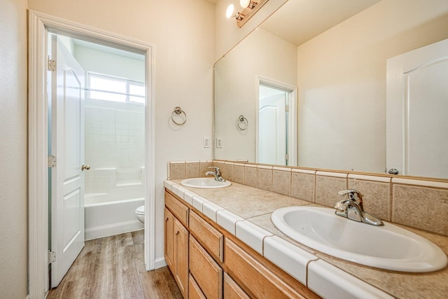 full bathroom with vanity, toilet, hardwood / wood-style flooring, and bathing tub / shower combination