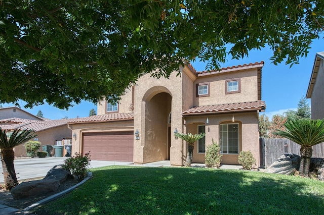 mediterranean / spanish home with a front yard and a garage