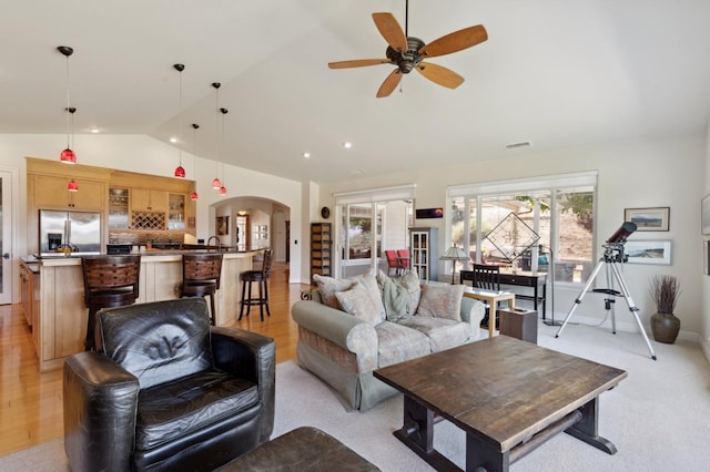 living room featuring ceiling fan, lofted ceiling, light wood-type flooring, and sink