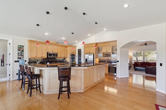 kitchen featuring appliances with stainless steel finishes, light hardwood / wood-style floors, light brown cabinets, and ceiling fan