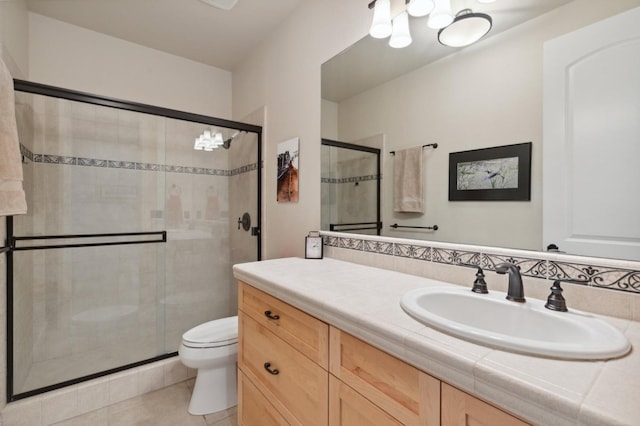 bathroom featuring vanity, toilet, tile patterned floors, and an enclosed shower