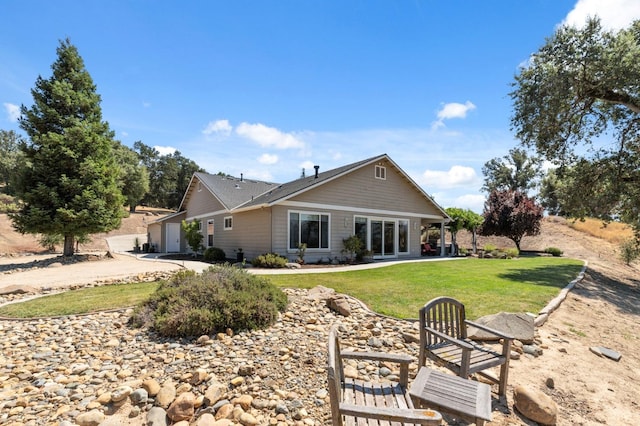 rear view of house with a garage and a lawn