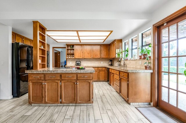 kitchen with sink, black refrigerator, tasteful backsplash, and a kitchen island