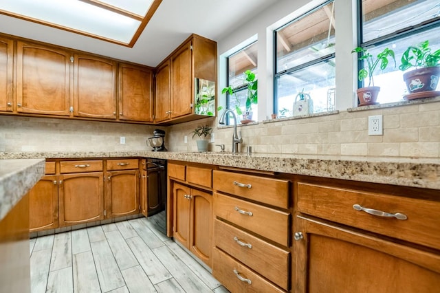 kitchen with light hardwood / wood-style floors, sink, and tasteful backsplash