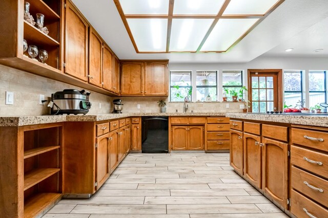 kitchen with light wood-type flooring, backsplash, sink, and black appliances