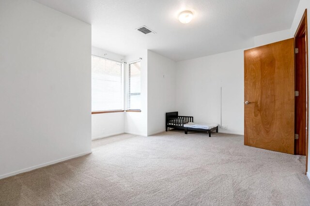 unfurnished room featuring light colored carpet