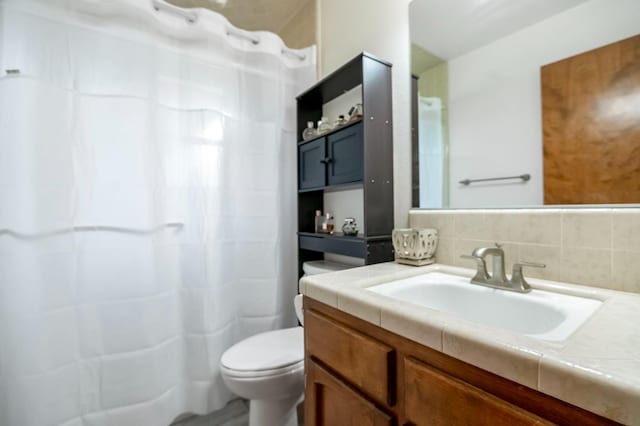 bathroom with vanity, toilet, a shower with shower curtain, and tasteful backsplash