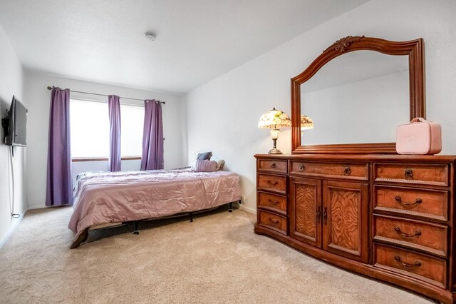 bedroom with lofted ceiling and light colored carpet