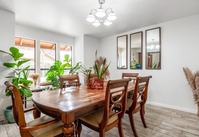 dining area with an inviting chandelier and light hardwood / wood-style floors