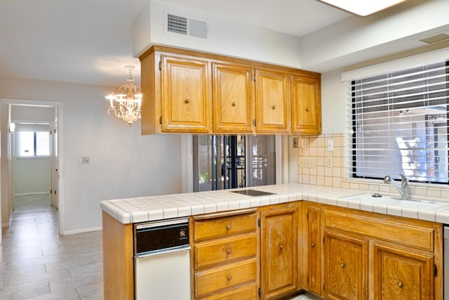 kitchen featuring a chandelier, tasteful backsplash, sink, kitchen peninsula, and tile countertops