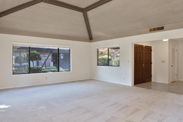 unfurnished room with vaulted ceiling with beams and light colored carpet