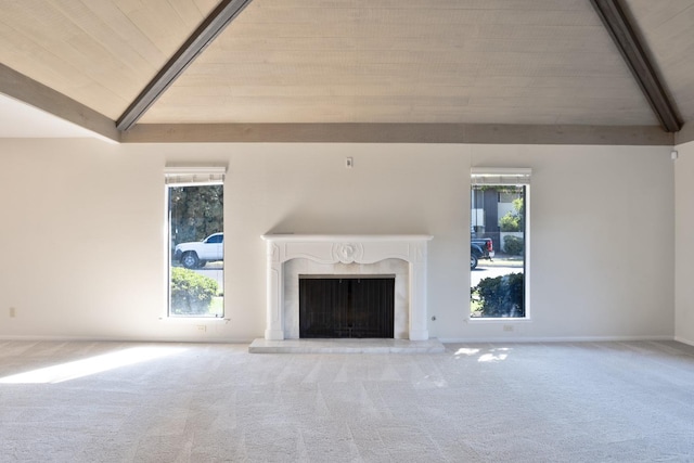 unfurnished living room featuring vaulted ceiling with beams, carpet flooring, a high end fireplace, and wooden ceiling