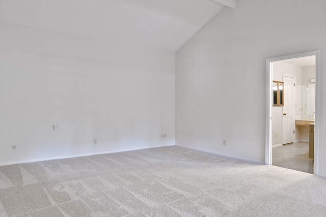 carpeted spare room with vaulted ceiling