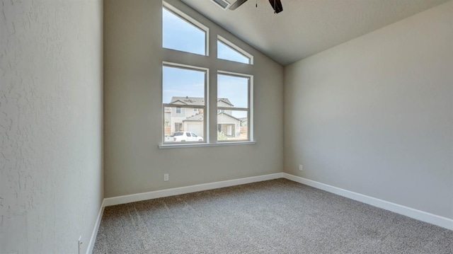 spare room featuring carpet flooring, vaulted ceiling, and ceiling fan