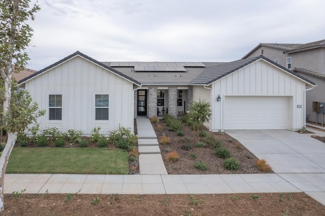 view of front of property with a garage and solar panels