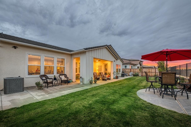 back of property featuring a patio, central AC, and a lawn