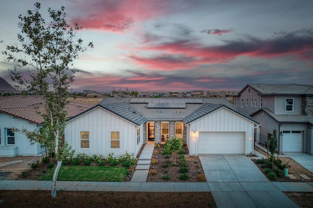 view of front facade featuring solar panels and a garage