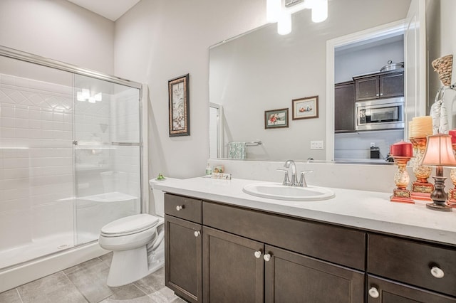 bathroom featuring vanity, a shower with shower door, toilet, and tile patterned floors