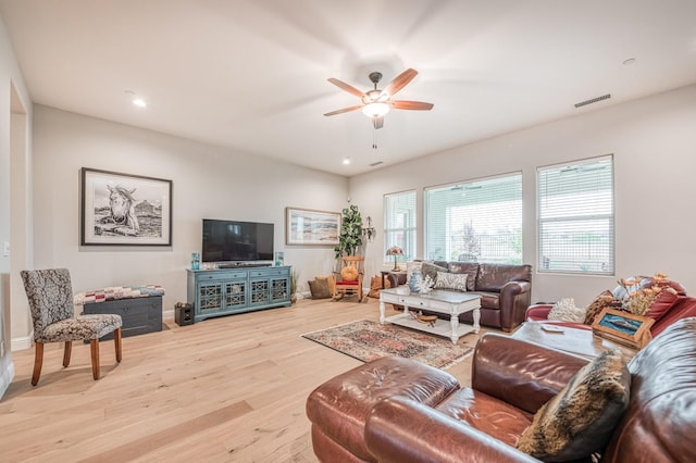 living room with light hardwood / wood-style flooring and ceiling fan