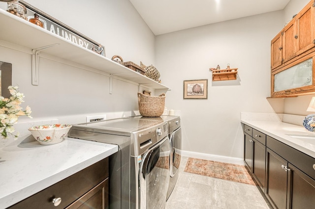 laundry room featuring washer and clothes dryer, light hardwood / wood-style floors, and cabinets