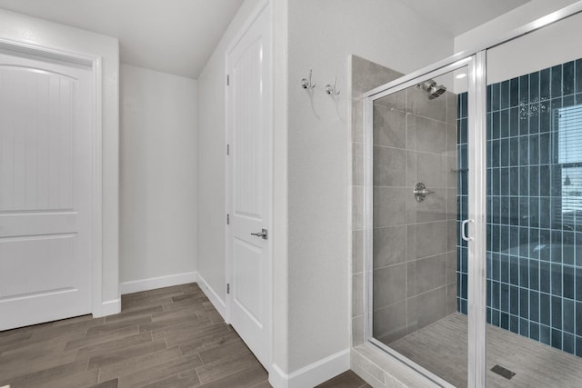 bathroom with walk in shower and hardwood / wood-style floors