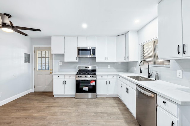 kitchen with sink, white cabinetry, appliances with stainless steel finishes, a healthy amount of sunlight, and ceiling fan