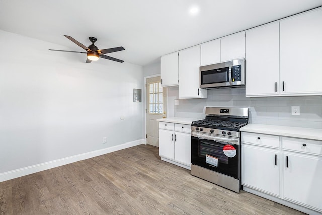 kitchen featuring white cabinetry, light hardwood / wood-style flooring, decorative backsplash, appliances with stainless steel finishes, and ceiling fan