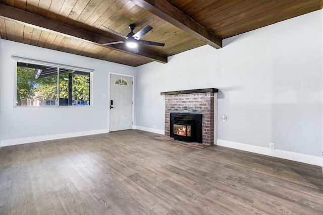 unfurnished living room featuring ceiling fan, beamed ceiling, wooden ceiling, a fireplace, and hardwood / wood-style floors