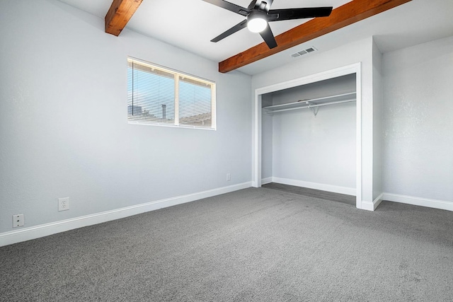 unfurnished bedroom featuring ceiling fan, carpet floors, a closet, and beam ceiling