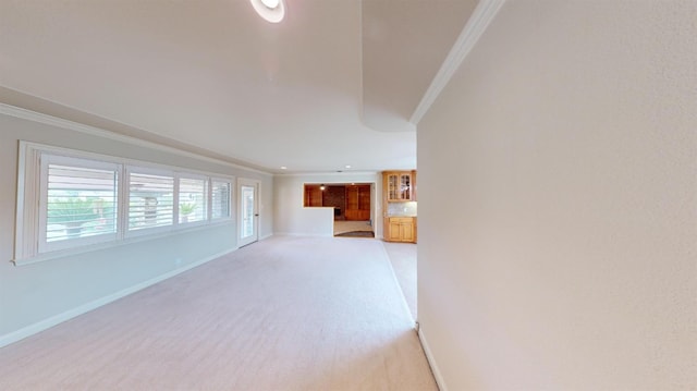 unfurnished living room featuring crown molding and light carpet