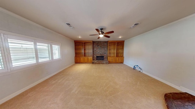 unfurnished living room featuring ceiling fan, light colored carpet, a brick fireplace, and ornamental molding