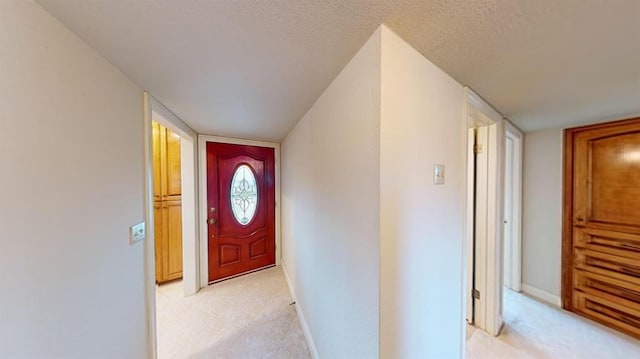 doorway to outside with a textured ceiling