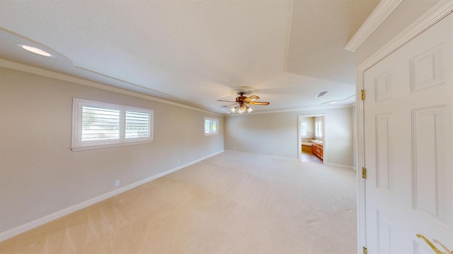 carpeted empty room featuring a textured ceiling, ceiling fan, and crown molding