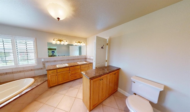 bathroom with vanity, a relaxing tiled tub, a textured ceiling, tile patterned floors, and toilet