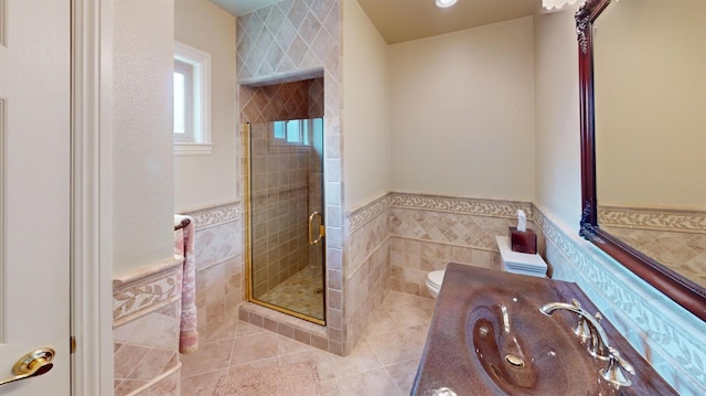 bathroom featuring tile walls, a shower with door, vanity, and toilet