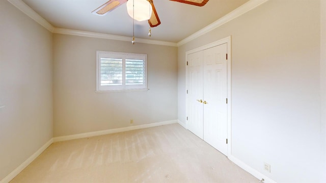 unfurnished bedroom with light carpet, a closet, crown molding, and ceiling fan