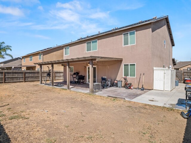 back of property with ceiling fan and a patio area